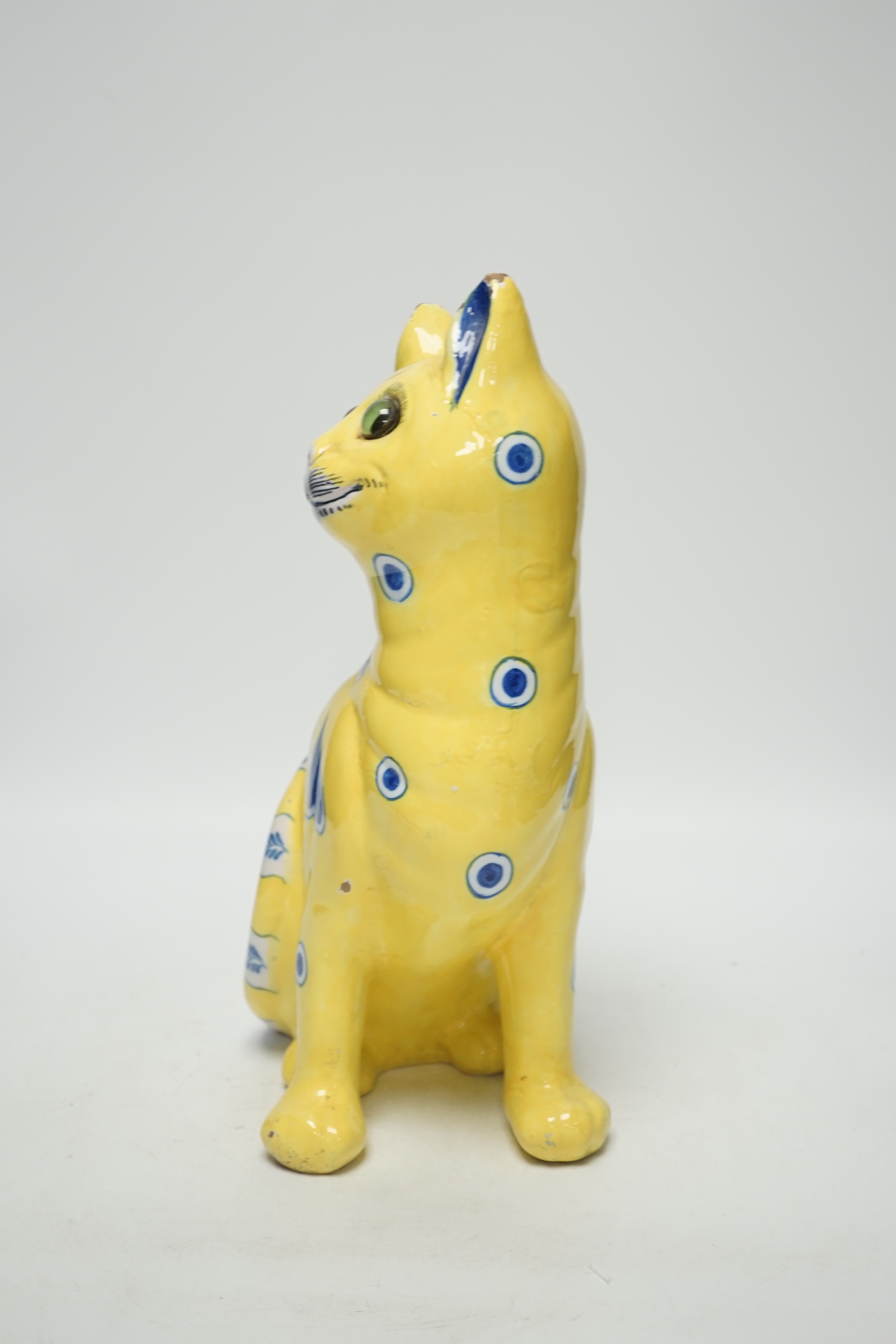 A Gallé yellow glazed model cat with glass eyes, signed E. Gallé, Nancy, 32cm high